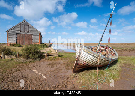 Una vecchia barca da pesca sotto un cielo blu a Thornham sulla costa nord di Norfolk Foto Stock