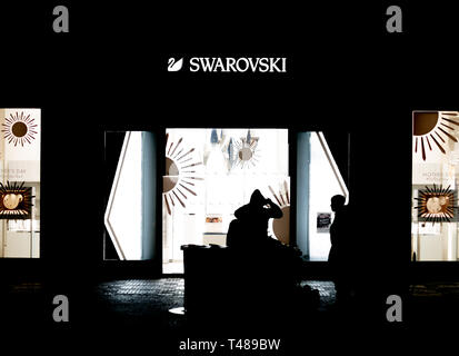 Praga, Czechia - 10APRILE 2019: un paio di sedersi davanti a un negozio di Swarovski a tarda notte in Praga Foto Stock