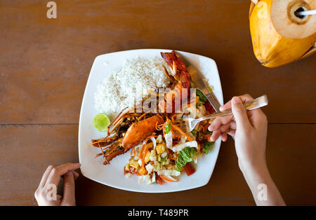 Ragazza avente jungle gamberetti in un ristorante di prospettiva in prima persona Foto Stock