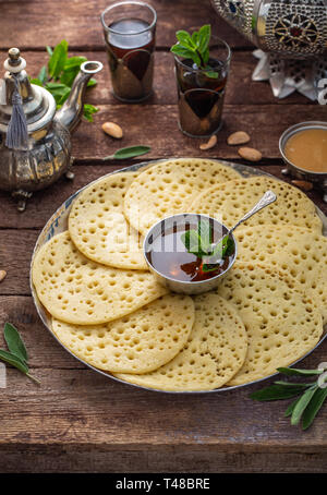 Frittelle marocchine Baghrir servita con pasta di mandorle, miele e tè alla menta Foto Stock