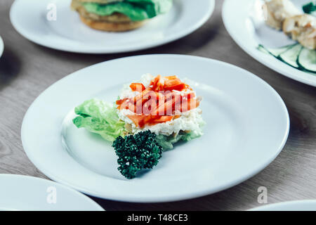 Hamburger, insalata di verdure e altri piatti sul tavolo nel ristorante . il fast food Foto Stock