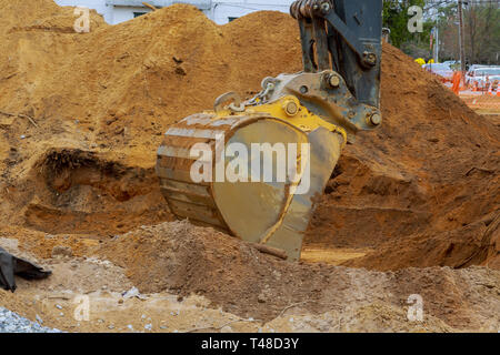 Sito in costruzione fondazione con escavatore lavora nella fossa di scavo case in costruzione Foto Stock