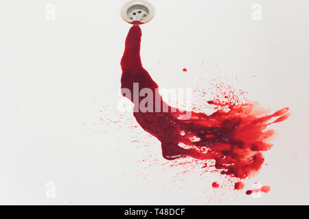 Il drenaggio del sangue dal bagno bianco bacino. Macchie di sanguinose nel foro waterbasin. Eseguire il sink con il sangue di inondazioni. La vernice rossa dripples al una bacinella svuotare Foto Stock