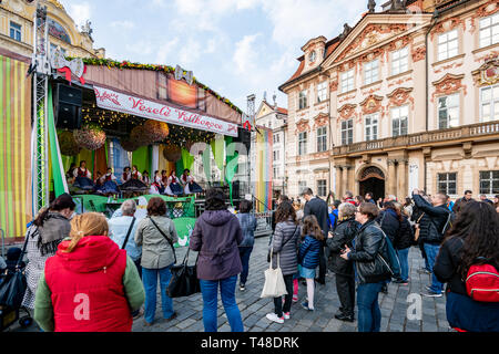 La folla guarda i bambini della scuola di eseguire sul palco durante Pragues Pasqua celebrazioni di Mercato nella piazza della Città Vecchia Foto Stock