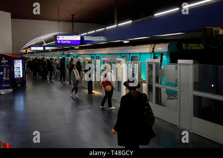 Persone sulla piattaforma di Parigi Metro Ligne 13 stazione "Invalides" uno di molte stazioni dotate di porte della piattaforma, Parigi, Francia Foto Stock