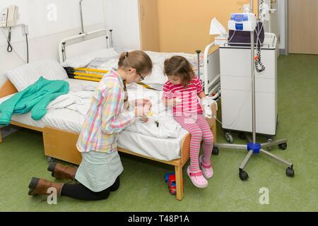 Ragazza 3 anni, visita della sorella, 12 anni, nell ospedale, Germania Foto Stock