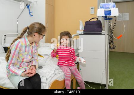 Ragazza 3 anni, visita della sorella, 12 anni, nell ospedale, Germania Foto Stock