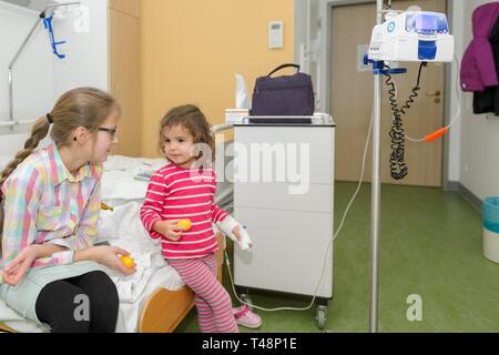 Ragazza 3 anni, visita della sorella, 12 anni, nell ospedale, Germania Foto Stock