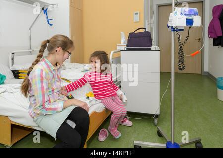 Ragazza 3 anni, visita della sorella, 12 anni, nell ospedale, Germania Foto Stock