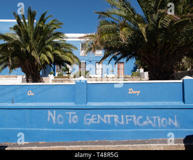 Cape Town, Sud Africa. Casa nel Quartiere Malay, Bo-Kaap. Dipinto sulla parete è lo slogan: No alla Gentrification. Foto Stock