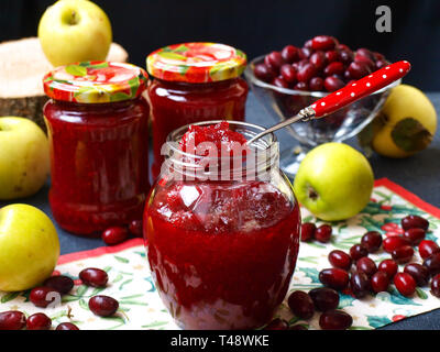 La marmellata di sanguinello e mele si trova nei vasi sul tavolo, un vaso è aperto, preparazione di inceppamento per l'inverno Foto Stock