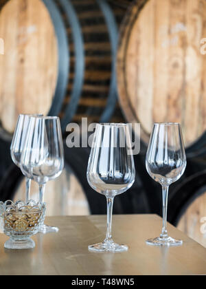 Svuotare bicchieri di vino nella parte anteriore del vino in legno barili. Foto Stock