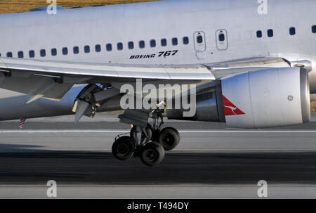 Vista ravvicinata del principale di atterraggio e motore di un Qantas Boeing 767 aereo di linea di atterraggio. Foto Stock