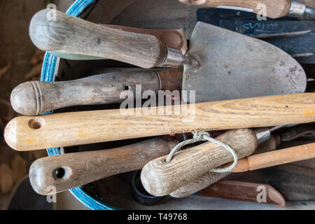 Una selezione di cazzuole e attrezzi da giardino in un trug Foto Stock