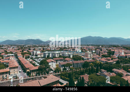 Vista panoramica della città di Pisa con edifici storici e lontane montagne dalla Torre di Pisa. Giorno di estate sole e cielo blu Foto Stock