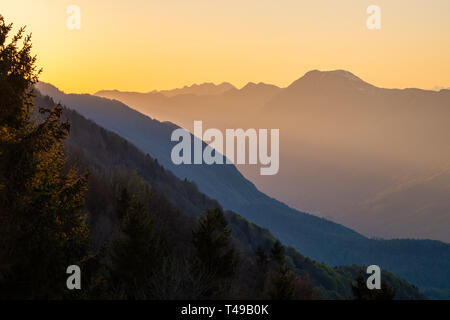 Vista dalla strada di confine di Italia e Slovenia su Soca valle di montagna Stol nelle Alpi Giulie in serata con il tramonto Foto Stock
