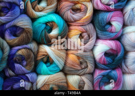 Sfondo di lana colorata matassa. matassa di filo, filo colorato in matasse, rosso giallo blu rosa viola raccolta del filo Foto Stock