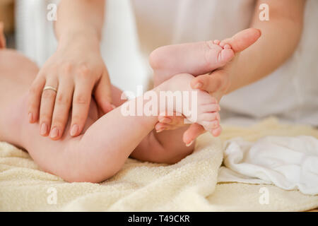 Giovane donna massaggio delicatamente baby, close up Foto Stock