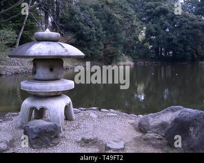 Lanterna di pietra e un laghetto in giardino giapponese Foto Stock