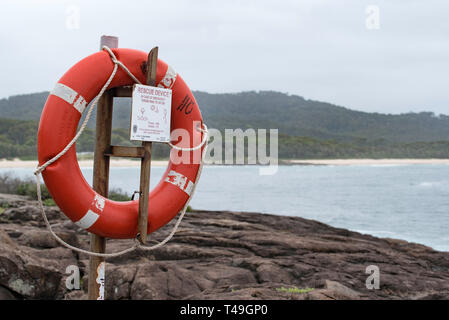 Una boa di vita o un dispositivo di galleggiamento montato vicino ad una popolare zona di pesca della roccia a Kioloa Beach sulla costa meridionale del nuovo Galles del Sud dell'Australia Foto Stock