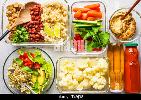 Vegano sano cibo in contenitori di vetro, vista dall'alto. Riso, fagioli, verdure, hummus e succhi di frutta per take-away a pranzo Foto Stock
