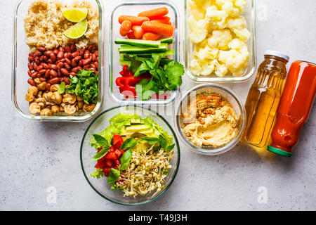 Vegano sano cibo in contenitori di vetro, vista dall'alto. Riso, fagioli, verdure, hummus e succhi di frutta per take-away a pranzo Foto Stock