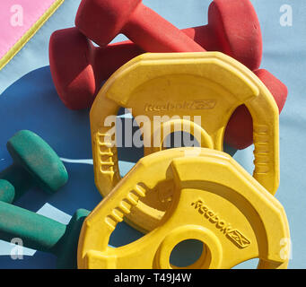 Una selezione di casa attrezzature da palestra su un colorato materassino yoga Foto Stock