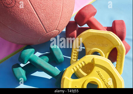 Una selezione di casa attrezzature da palestra su un colorato materassino yoga Foto Stock