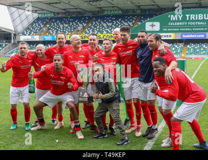 Windsor Park, Belfast, Irlanda del Nord, Regno Unito. Xiv Apr, 2019. 'My omaggio' - una celebrità partita di calcio organizzato da Sellebrity Soccer con Calum Best (figlio del compianto George Best, Irlanda del Nord e il Manchester United legenda) una delle forze trainanti, insieme con gli altri, dietro di esso. La manifestazione ha lo scopo di raccogliere fondi per NACOA (Associazione Nazionale per i bambini di alcolisti) e irlandesi FA Foundation. Azione dall'evento di oggi. Paolo Boschi lato sollevare il trofeo. Credito: David Hunter/Alamy Live News. Foto Stock