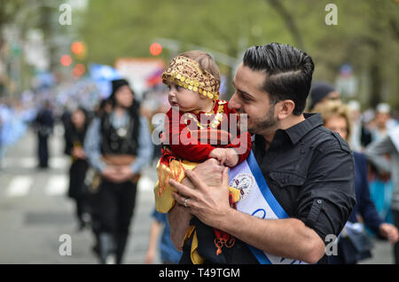 Un uomo visto marciando con il suo bambino durante il greco Independence Day parade lungo la Quinta Avenue a Manhattan. Foto Stock