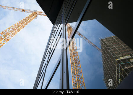 Hannover, Germania. Xi Apr, 2019. Una costruzione di gru e un edificio in costruzione sono riflesse in un vetro anteriore. Credito: Moritz Frankenberg/dpa/Alamy Live News Foto Stock