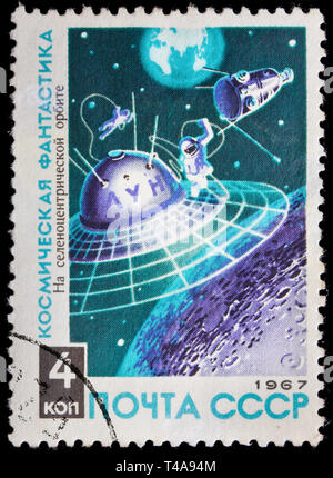 Unione Sovietica - circa 1967: un timbro stampato in URSS cosmonauti mostra in uno spazio aperto al di sopra di luna, fantascienza, circa 1967 Foto Stock
