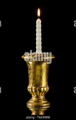 Candela in golden vintage candelabro isolati su nero con la riflessione Foto Stock