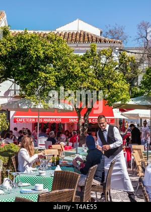 MARBELLA Alfresco pranzo cameriere servizio Orange Square Plaza de los Naranjos, ristorante all'aperto, persone che godono di cibo pasto e bevande Old Town Marbella Spagna Foto Stock