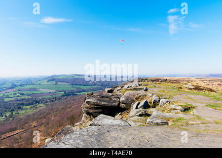 Parapendio a svettare su bordo Curbar, nel Derbyshire Peak District su un vago giornata di primavera. Foto Stock