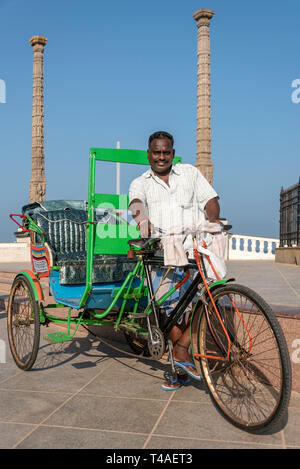 Vista verticale di un ciclo rickshaw proprietario e il suo veicolo di Pondicherry, India. Foto Stock