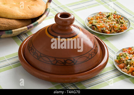 Marocchino tradizionale Tagine con insalata e pane sul tavolo per la cena Foto Stock