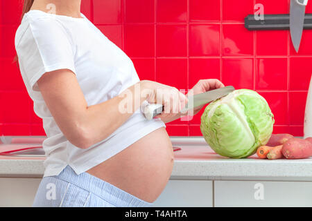 Donna incinta la preparazione di alimenti Foto Stock