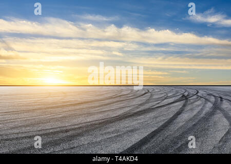 Gara di asfalto via terra e bellissimo cielo nuvole al tramonto Foto Stock