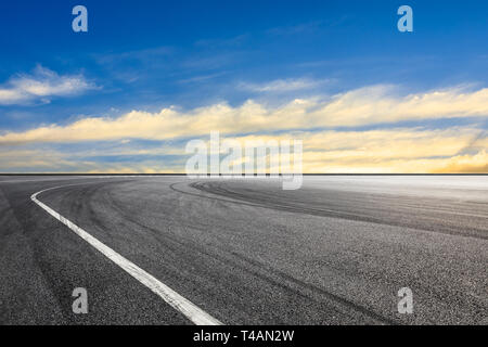 Gara di asfalto via terra e bellissimo cielo nuvole al tramonto Foto Stock