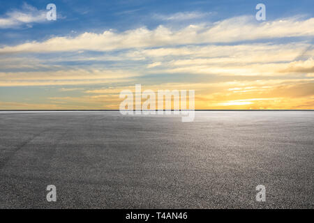 Gara di asfalto via terra e bellissimo cielo nuvole al tramonto Foto Stock