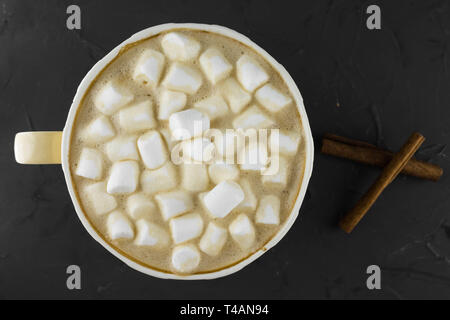 Bella tazza di caffè con marshmallow. Sfondo scuro. Lay piatto. Foto Stock