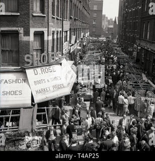 Anni sessanta, storico vista aerea da questa epoca di un trafficato mercato rionale, in Stepney, East London, Londra, Inghilterra, Regno Unito. In questa epoca, la zona era un povero ma vibrante borough, composto da una miscela di diversi popoli etnici, con una grande cultura di immigrati e di una forte popolazione ebraica. Foto Stock