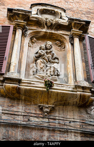 Bassorilievo medievale della Vergine Maria e Gesù bambino a Siena, Italia. Foto Stock