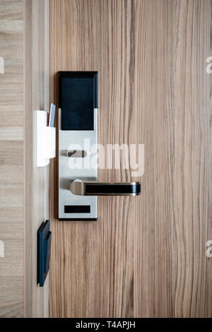 Scheda elettronica smart serratura sulla porta di legno presso l'hotel per alimentazione Foto Stock