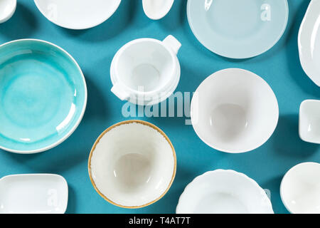 Ciotole in ceramica e piastre su sfondo blu - vista superiore Foto Stock