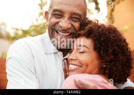 Senior uomo nero e la sua media di età compresa la figlia che abbraccia, close up