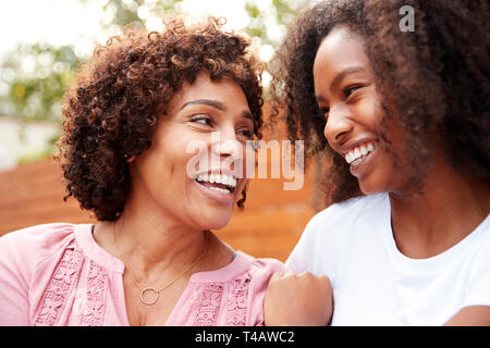 Medio nero invecchiati mamma e figlia teenager sorridente ad ogni altro Foto Stock