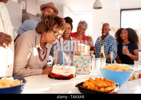 Persone di mezza età donna nera torta di taglio durante una famiglia composta da tre generazioni celebrazione di compleanno,close up Foto Stock