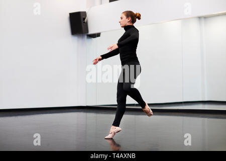 Studentessa a Performing Arts School ripassando balletto in studio di danza Foto Stock